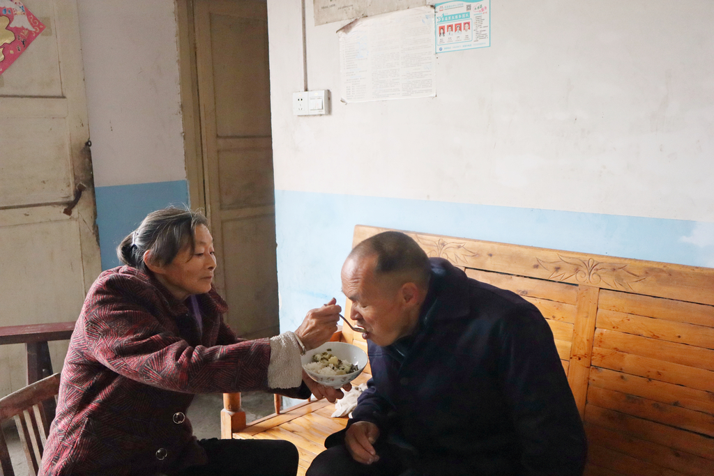 肖仕芬正在给小叔子张如雄喂饭。忠县县委宣传部供图