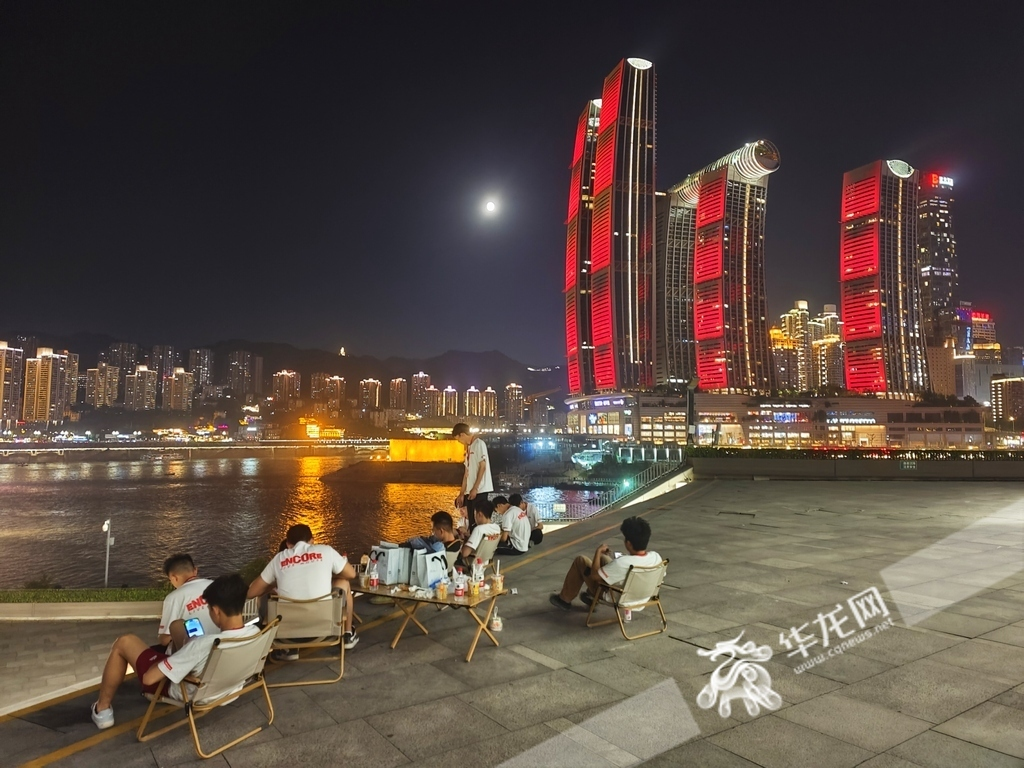 Many citizens gathered by the riverside at the Chongqing Grand Theatre to enjoy the cool evening air and take in the stunning lunar display