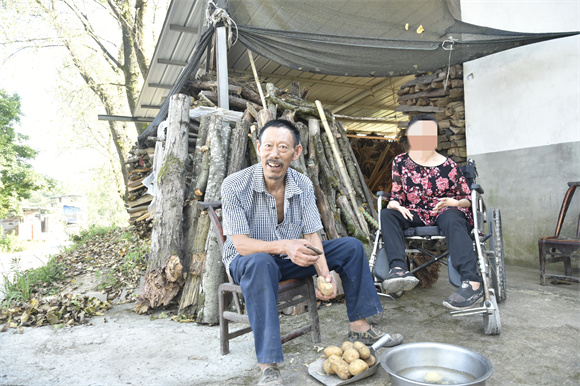 谭天平一边干家务活，一边陪妻子聊天。李歆宇 摄