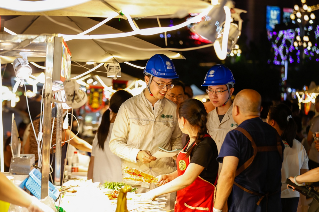 国网重庆市南供电公司员工在夜市内对摊主进行安全用电宣传。通讯员 龚超 摄