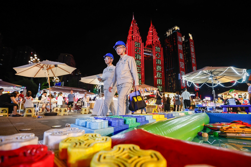 The Southern Power Supply staff inspecting power equipment at the night market (Photographed by Gong Chao)