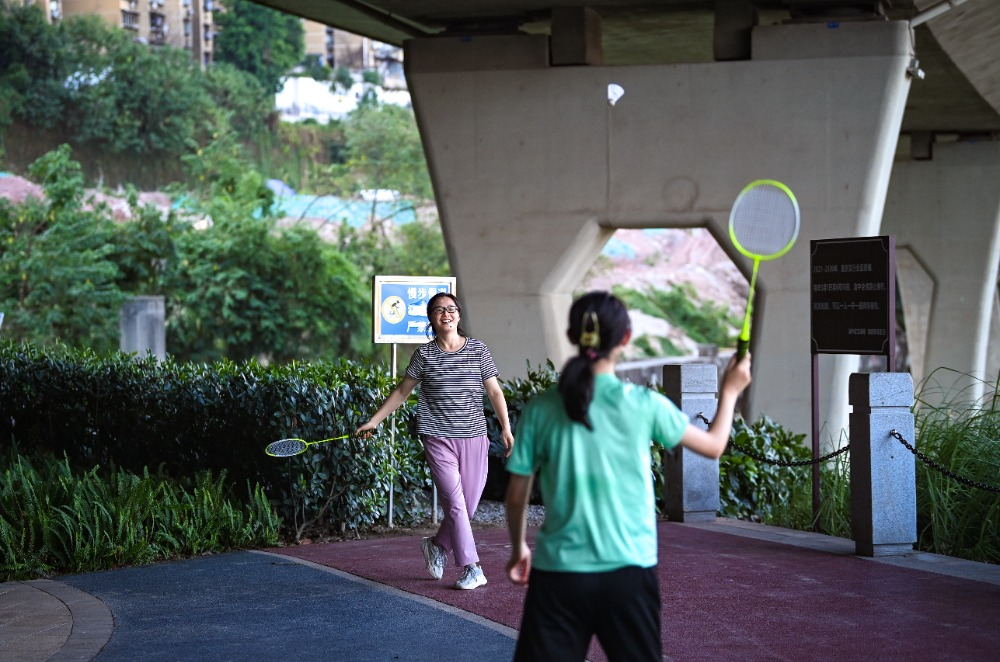 On August 24, at Jiulong Riverside Walkway, citizens playing badminton in the shade under the bridge