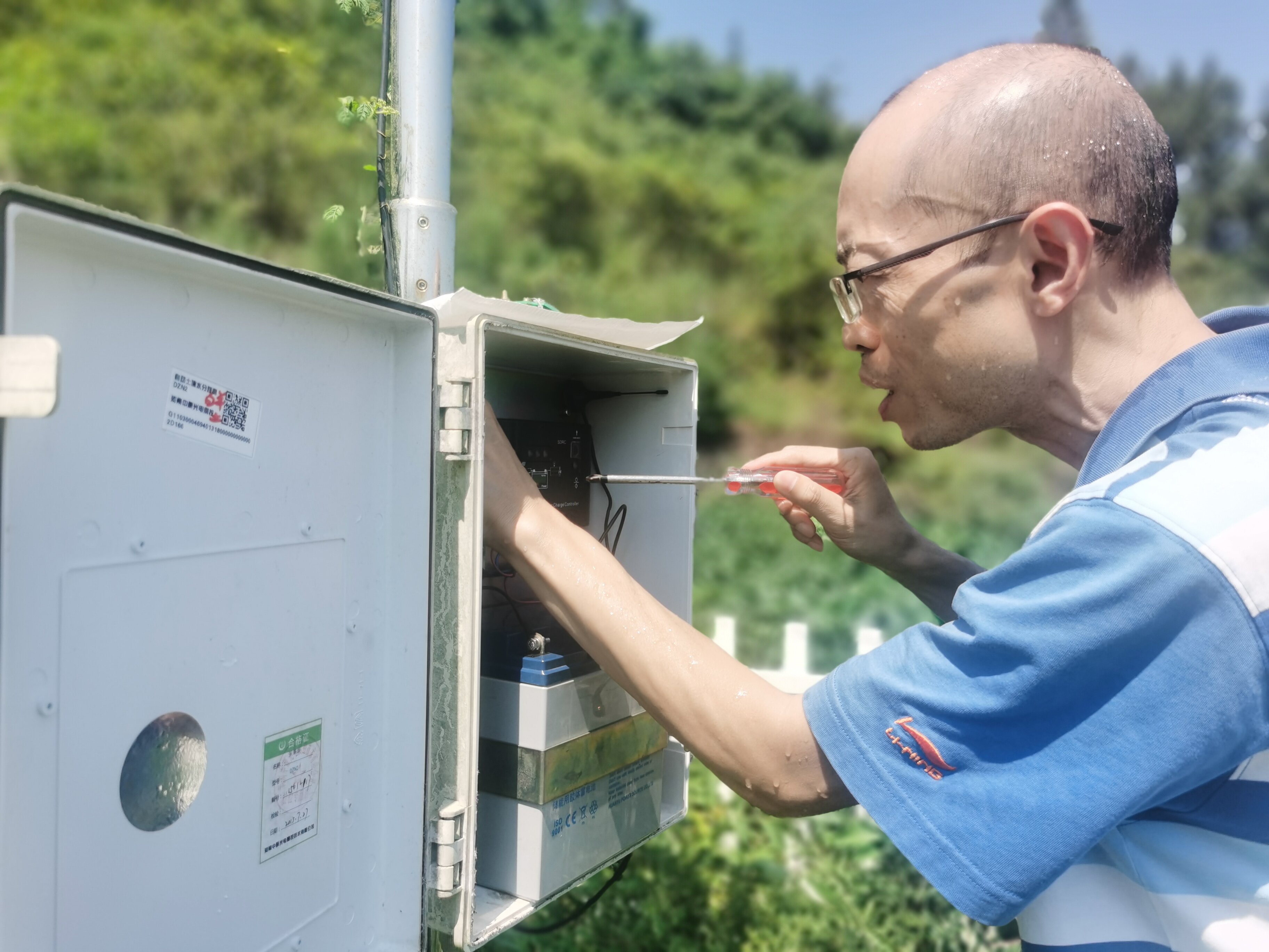 近日，万州区持续出现40℃以上高温，图为万州区气象局业务人员对白羊土壤水分站进行维护，确保气象数据监测稳定。摄影：张先俊。