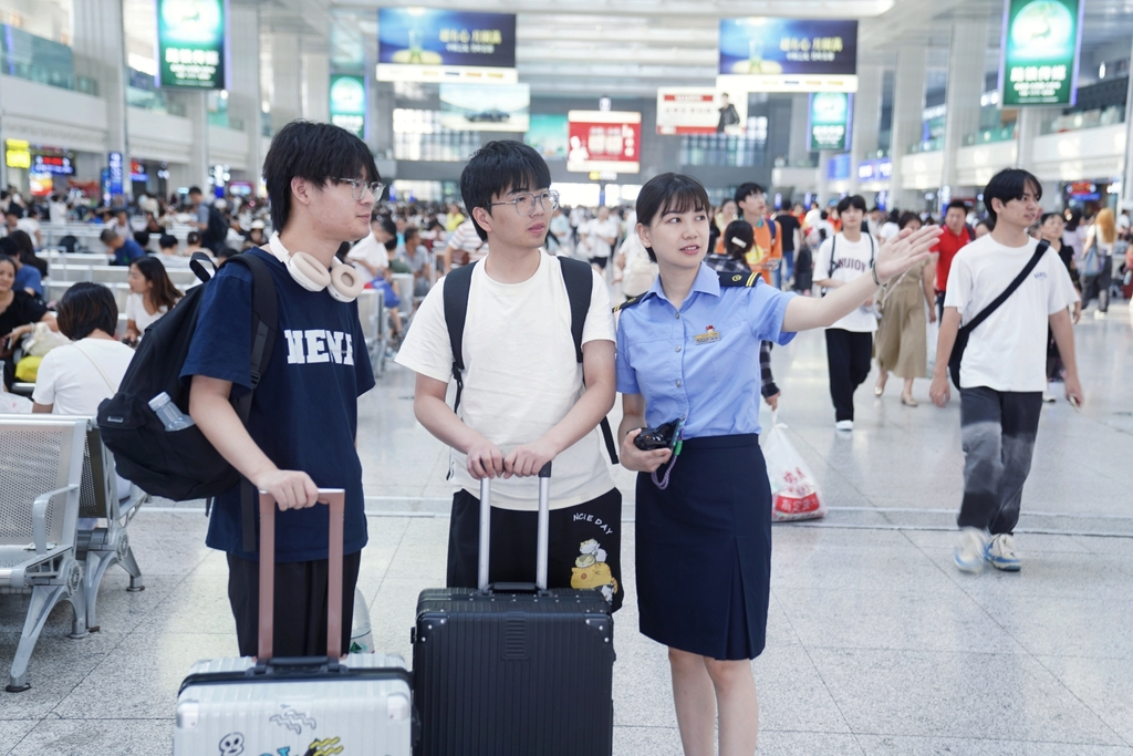 Staff of Chongqing North Railway Station guiding passengers to check in at the waiting hall (Photographed by Wang Liang)