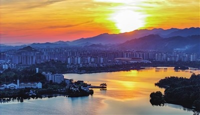 At Shuanggui Lake National Wetland Park, the sunrise ignites the lake with a fiery red, seemingly rousing the entire city from its slumber with a burst of energy