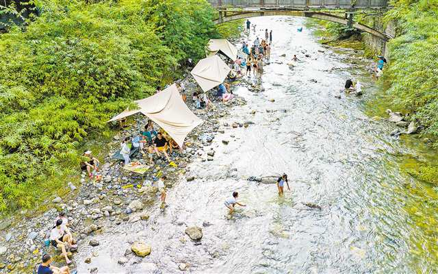 On August 3, visitors enjoyed catching fish and playing in the water by the Shizhong River at the Gold Buddha Mountain Tianxing Resort in Nancheng Sub-district, Nanchuan District