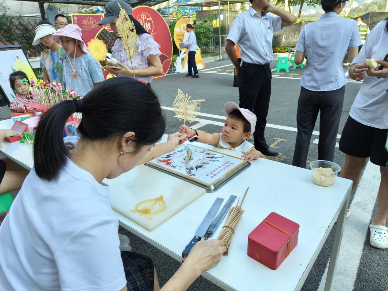 小朋友认真观看糖画、面人等制作。大竹林街道 供图 华龙网发