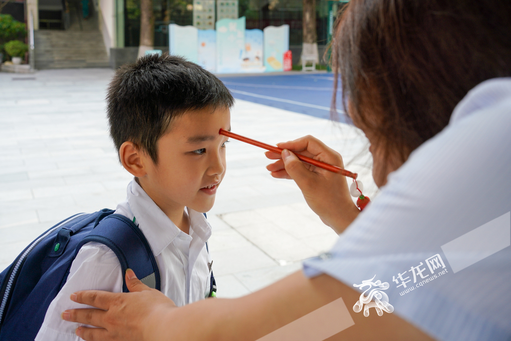 人和街小学，老师正在为一年级新生进行“朱砂启智”。 华龙网记者 杨琦 摄