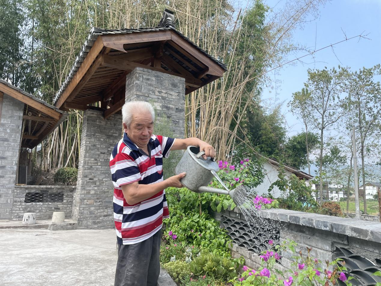 居民在改造后的屋前澆花。梁平區(qū)融媒體中心供圖 華龍網(wǎng)發(fā)