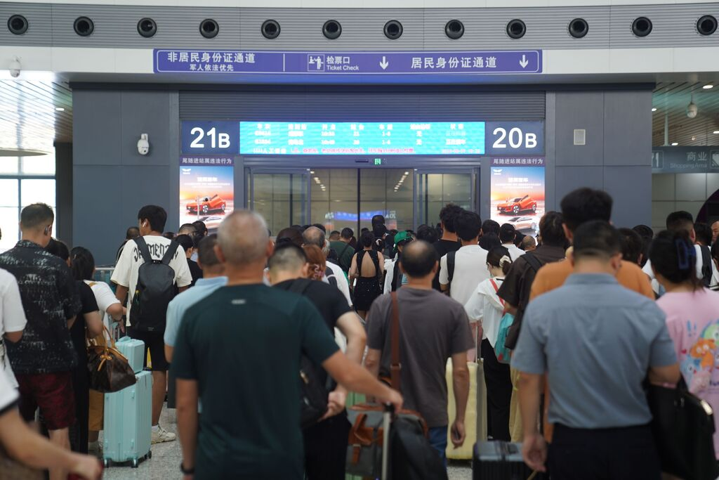 Passengers were seen orderly queuing for ticket checks and boarding