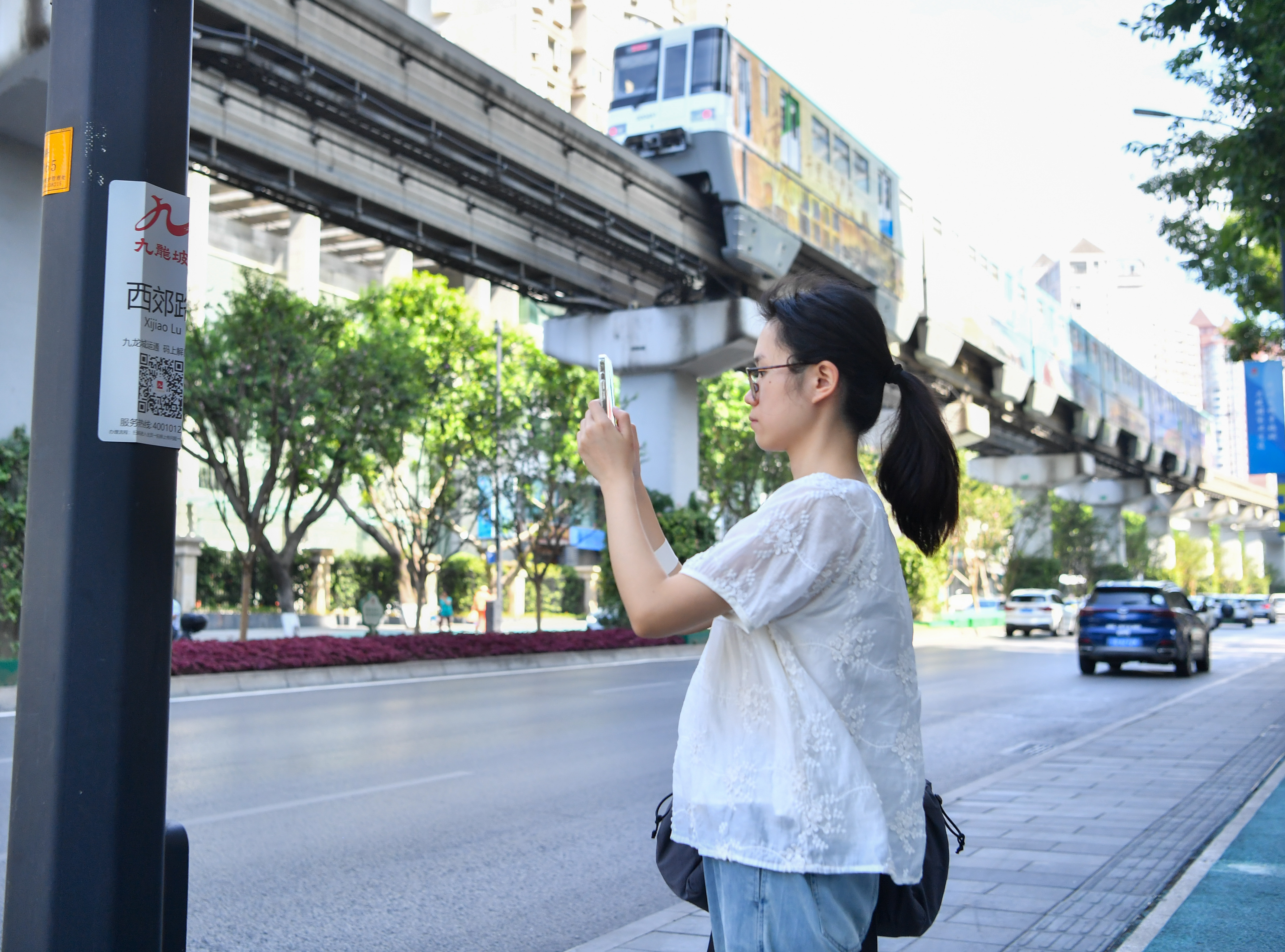 市民在西郊路掃描便民標識牌進入“九龍城運通”微信小程序獲取服務。通訊員 周邦靜 攝