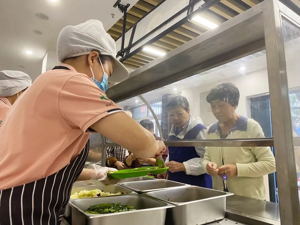 老人們老人正在南岸區團圓堡社區食堂打飯。