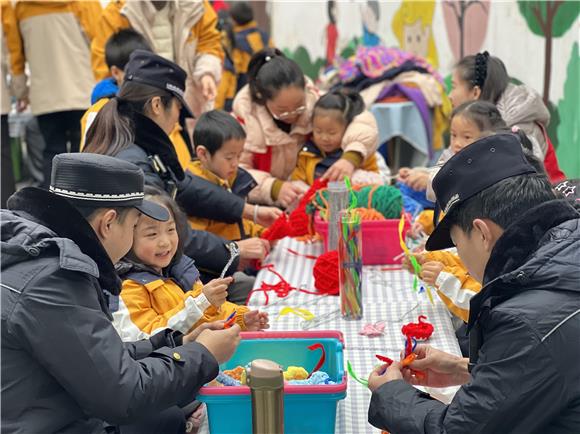 工作人員和小朋友們一起給大樹(shù)織毛衣。香爐山街道供圖