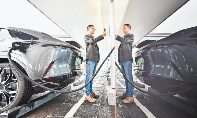 At an intelligent super charging demonstration station on Meiye Road, Nan'an District, a citizen charging his car at a liquid cooled super charging space by canning a QR code. (Photographed by Xie Zhiqiang / Visual Chongqing)