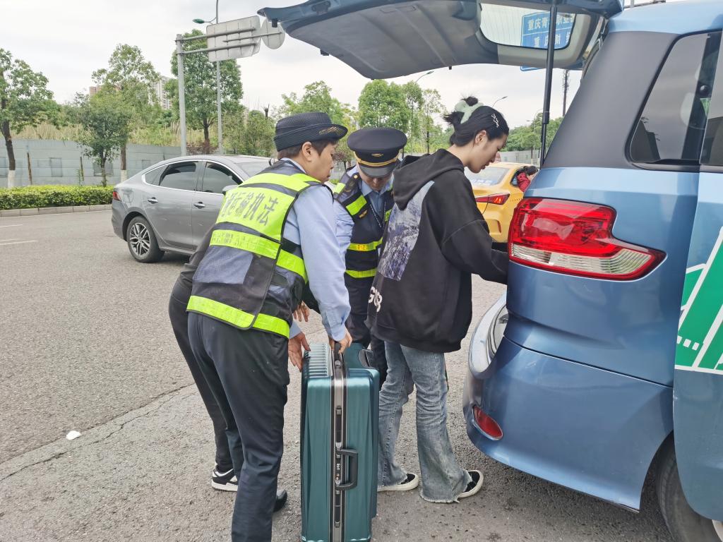 执法队员帮乘客搬行李上车。重庆交通执法部门供图