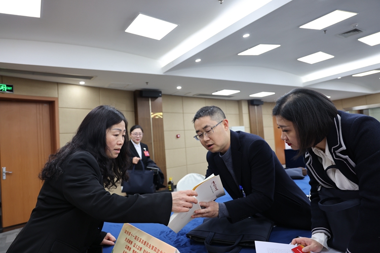 政協(xié)委員向大會報到，領(lǐng)取獨具“心意”的會議材料。巫溪縣政協(xié)供圖