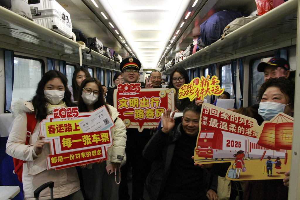 2025年1月14日春運(yùn)首日T10次列車上旅客們開心與列車工作人員合影，共同營(yíng)造文明出行的乘車環(huán)境。文佳 攝