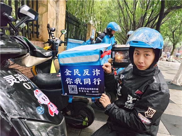 外賣騎手將反詐標語張貼在電動車后方的明顯位置。通訊員  胡琴 攝