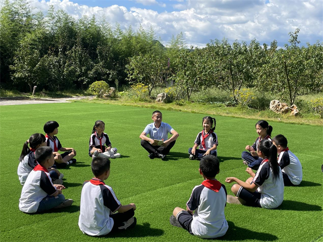 颜林带领孩子在阳光下阅读。梁平区委宣传部供图