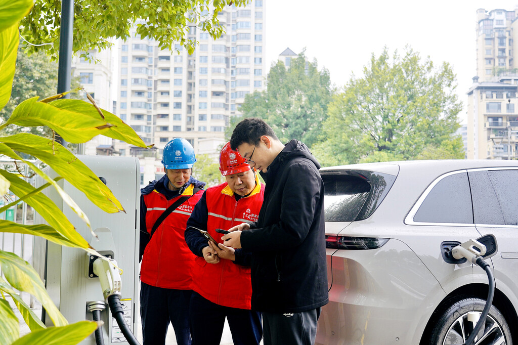 The employees of State Grid Chongqing Kaizhou Power Supply Company guide EV owners at the Gujin Square Supercharging Station