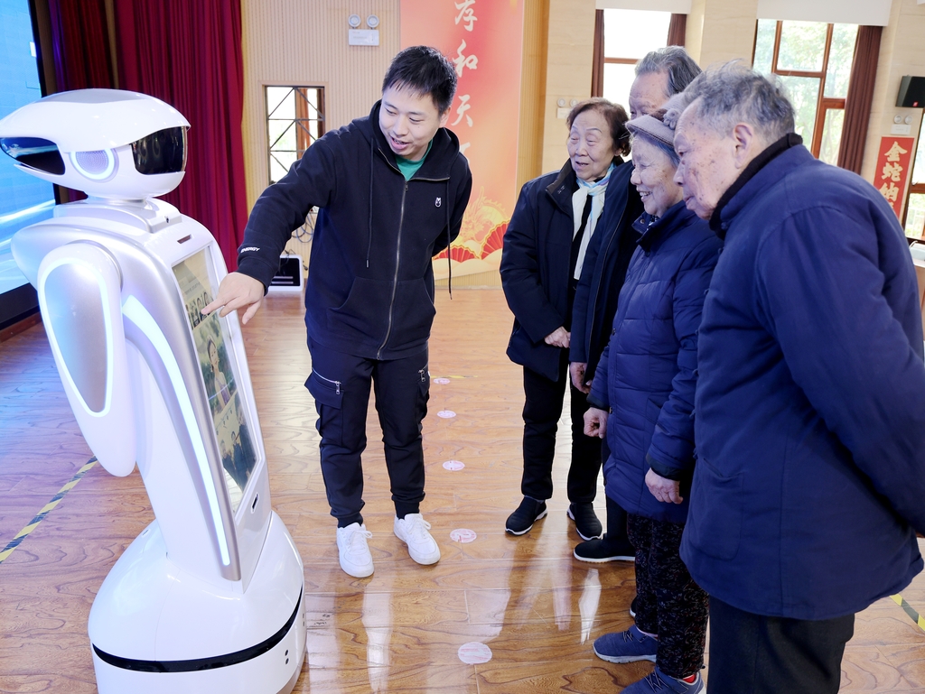 老人们与机器人“裴裴”温情互动。