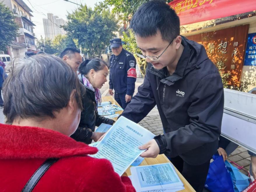 ▲图为工作人员正在向群众发放文明殡葬倡议书