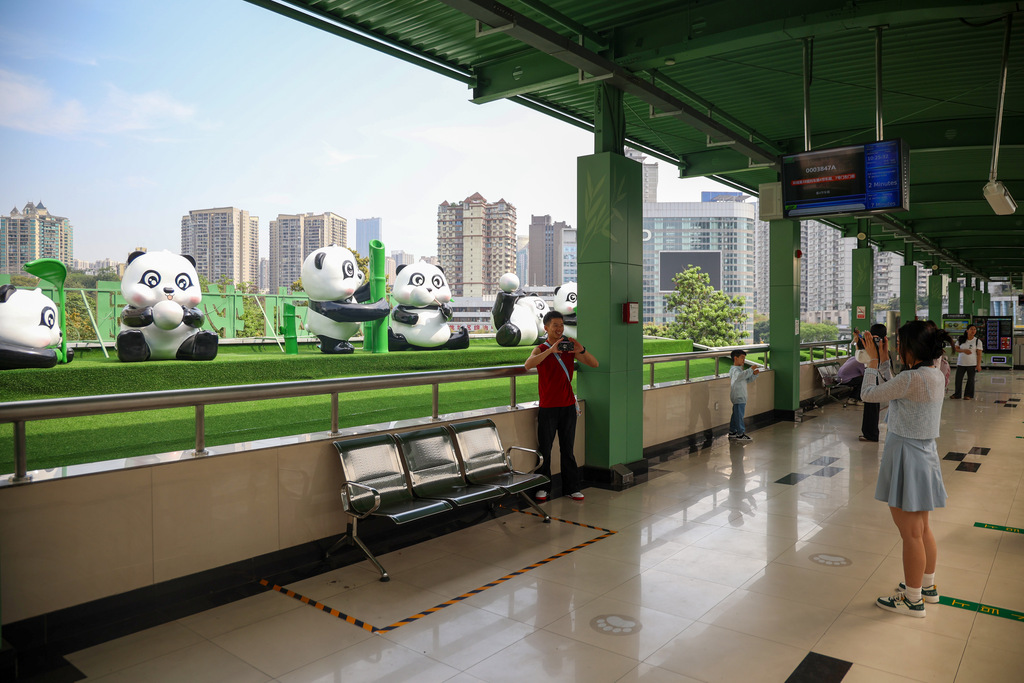 乘客和熊猫雕塑合影。重庆轨道集团供图