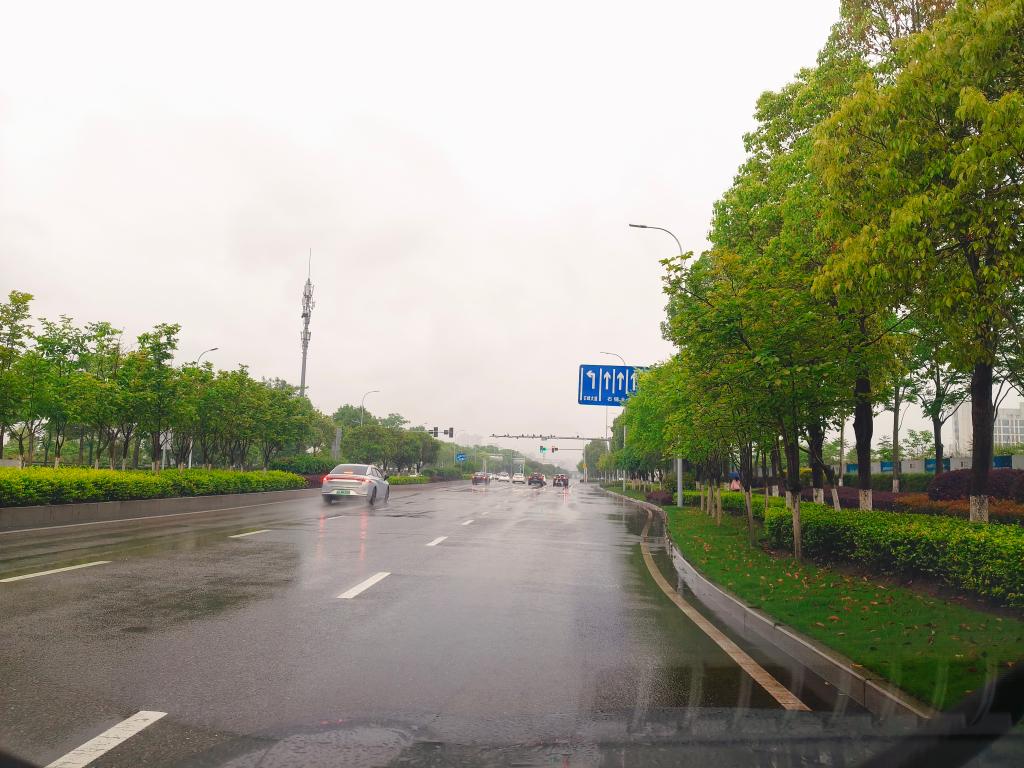 （确保安全情况下由乘坐副驾驶人员拍摄）交通信号灯调整后，晴天和下雨天该路口车辆行驶情况，左转拥堵问题已明显改善。 (2)