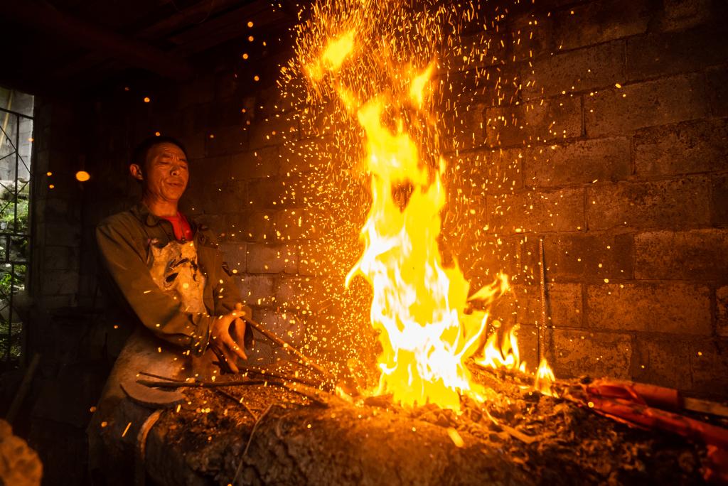 润溪乡铁匠铺师傅正在打铁。冉林  摄