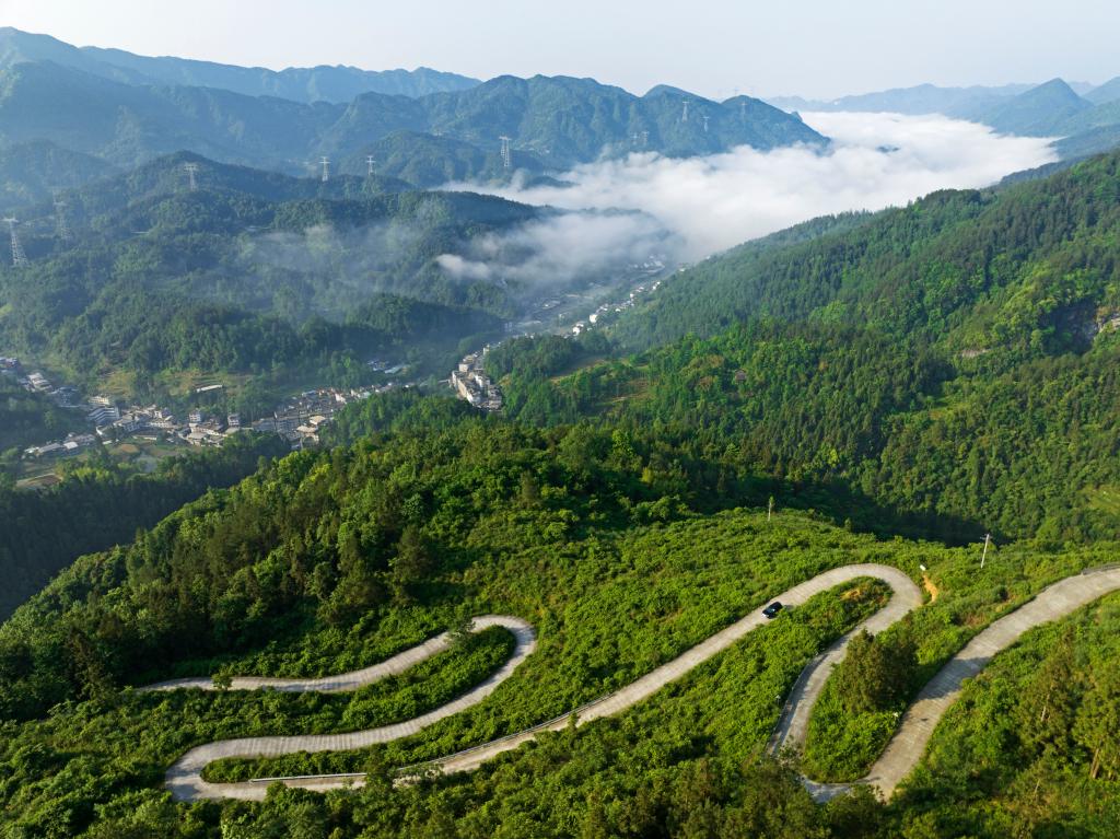 在太原镇，一条盘山路蜿蜒穿梭在崇山峻岭之间，连通着村村寨寨，车辆行驶在盘山公路上，与晨雾、远山、村庄共同构成了一幅壮美的乡村画卷。