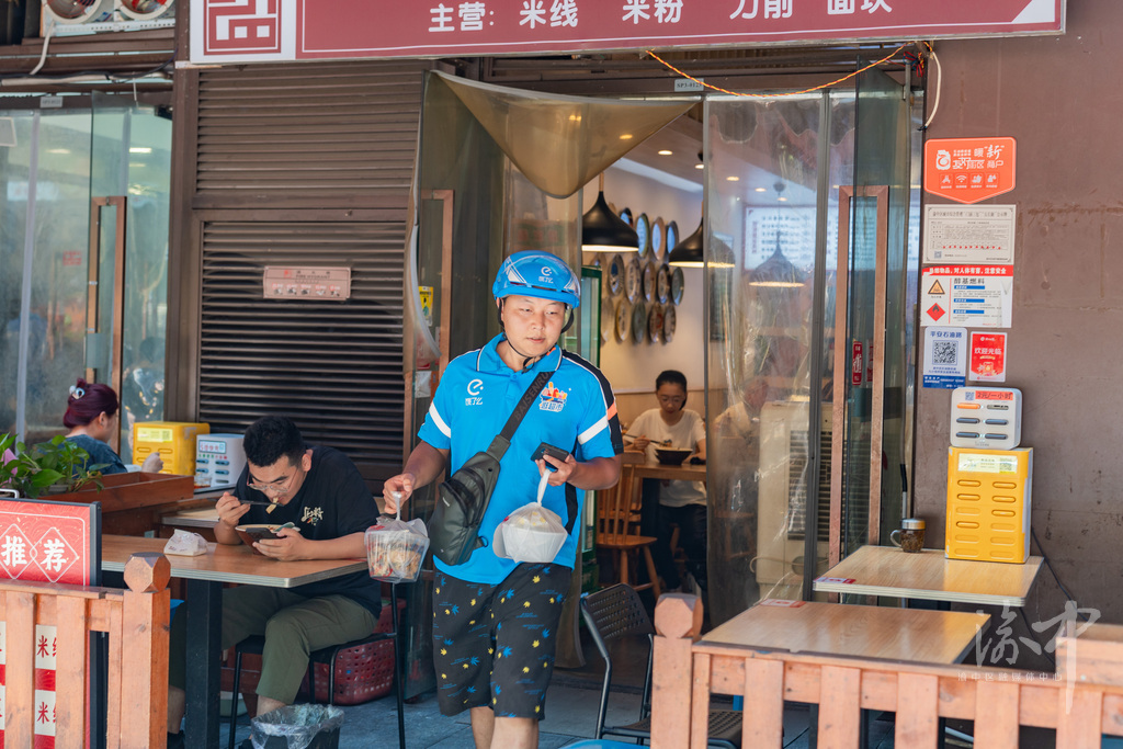 快递小哥在友好商户出取餐