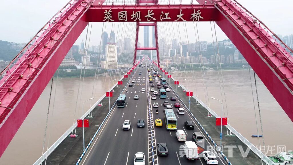 鲜艳的国旗装点菜园坝大桥的拱形桥身，与车流共舞，跃动节日欢歌。第1眼TV-华龙网记者 罗盛杰 摄