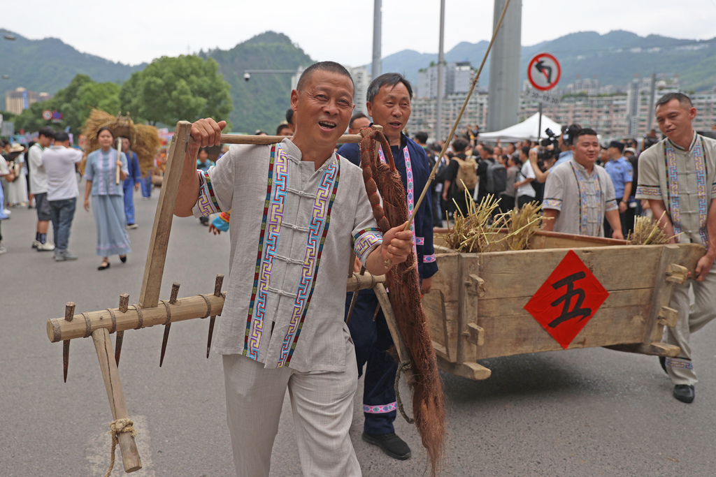2025年5月30日，重庆市彭水苗族土家族自治县举行端午非遗大巡游活动。图为当地村民正在展示农具。