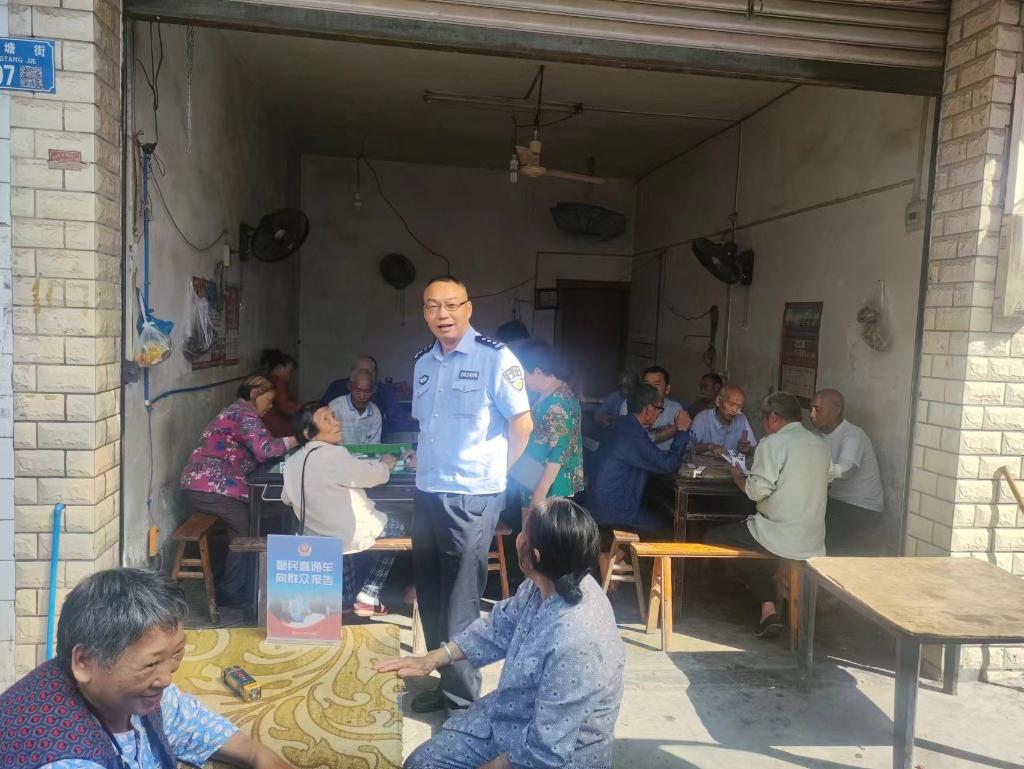 7月2日李市派出所民警在洞塘村向群众报告