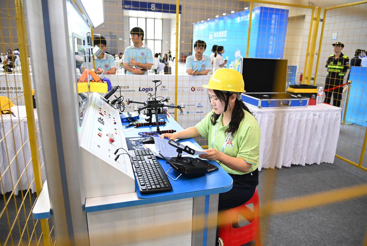 7-6月25日，重庆国际博览中心，重庆市沙坪坝区选手谢翠娟参加“第二届“一带一路”国际技能大赛无人机装配检修项目比赛。