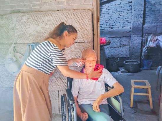 网格员上门为行动不便的老人办理业务。