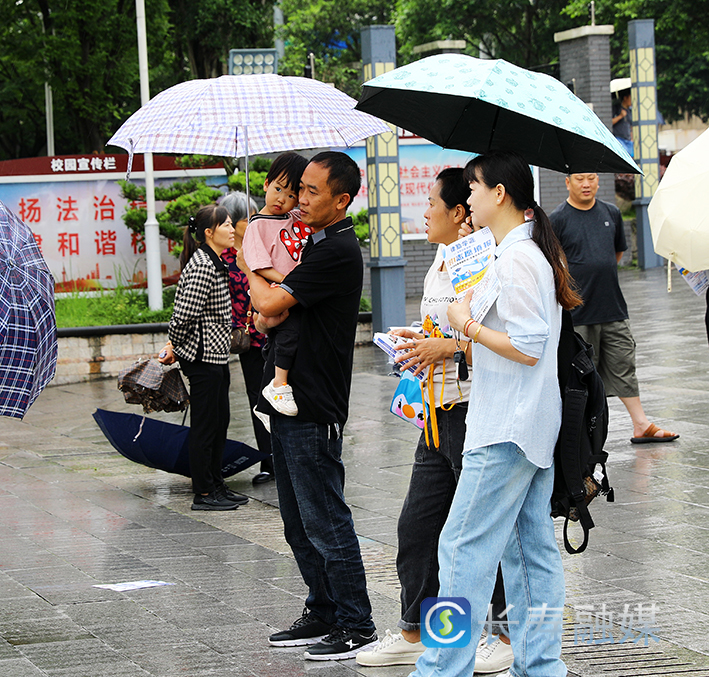 雨中送考的父亲和女儿一起“战斗”