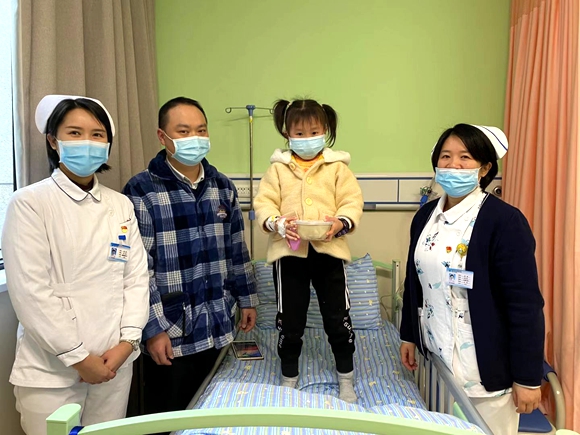 儿童患者与家人领过羊肉汤与医护人员合影。渝北区人民医院供图