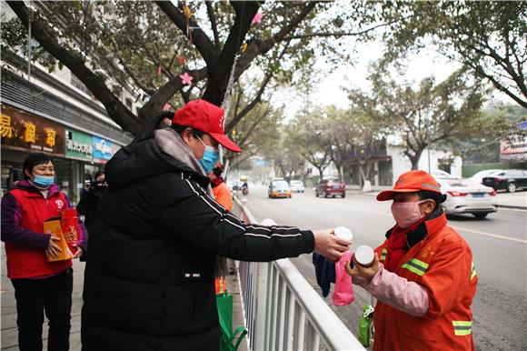 巾帼志愿者向环卫工赠送腊八粥。通讯员 陈仕川 摄