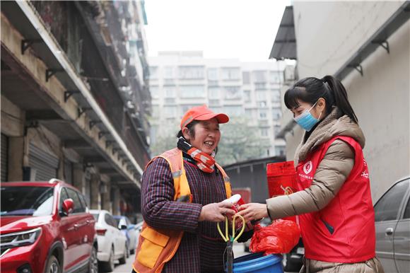 巾帼志愿者向一线工作人员赠送腊八粥。通讯员 陈仕川 摄