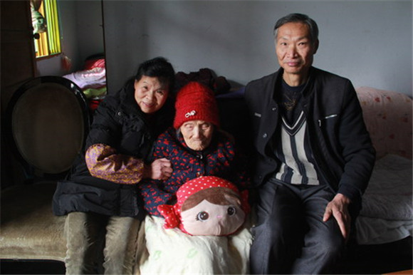 黄建（右一）、刘明旗（左一）夫妇照顾奶妈唐术英老奶奶。 特约通讯员 周云 摄