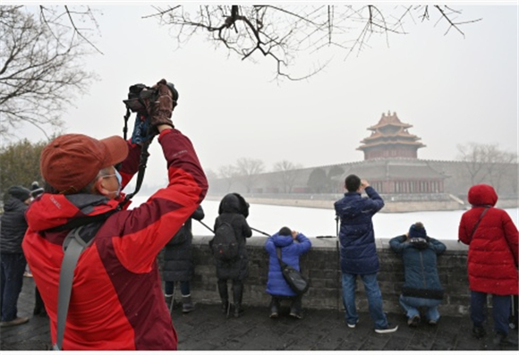 摄影爱好者在拍摄故宫角楼雪景。新华社记者 李鑫 摄