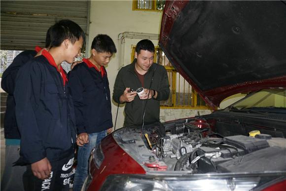 该校学生跟从“双师型”教师学修车技术。特约通讯员 邓小强 摄