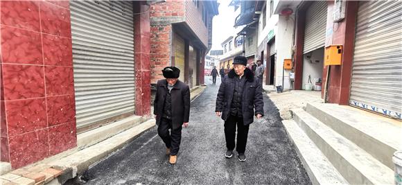 2两位老人沿着草油路散步。特约通讯员 赵武强 摄