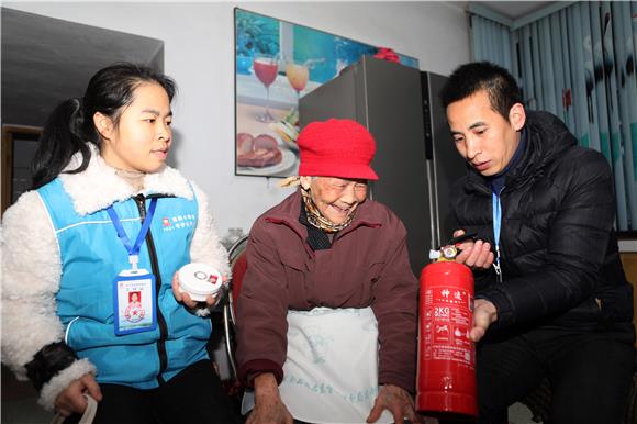 工作人员向84岁的张淑芳讲解干粉灭火器的功能和作用 通讯员 陈仕川 摄