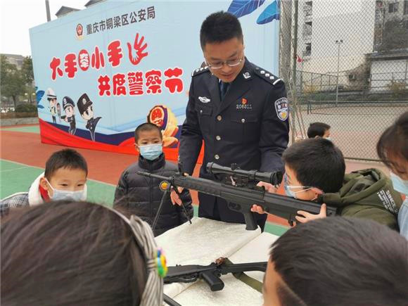 警察叔叔带着孩子们了解枪支等器械。 特约通讯员  谢凤 摄