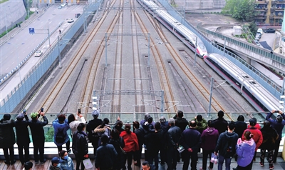市民在金沙天街观景台看“高铁穿楼”。