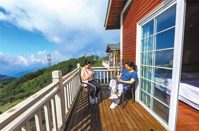 游客在佛印山小木屋宽大的阳台上沐浴阳光。