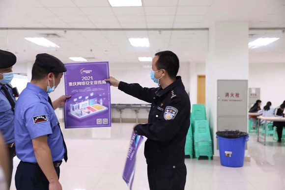 辖区民警向企业员工展示宣传海报。重庆高新区公安分局供图