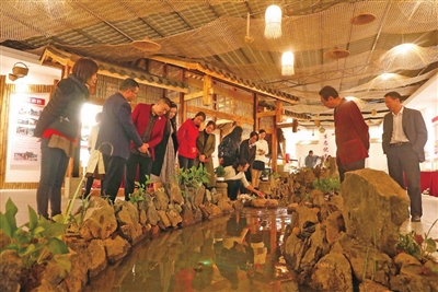 七星镇金柱村村情陈列馆，游客在室内的溪流旁参观。通讯员 向成国 摄